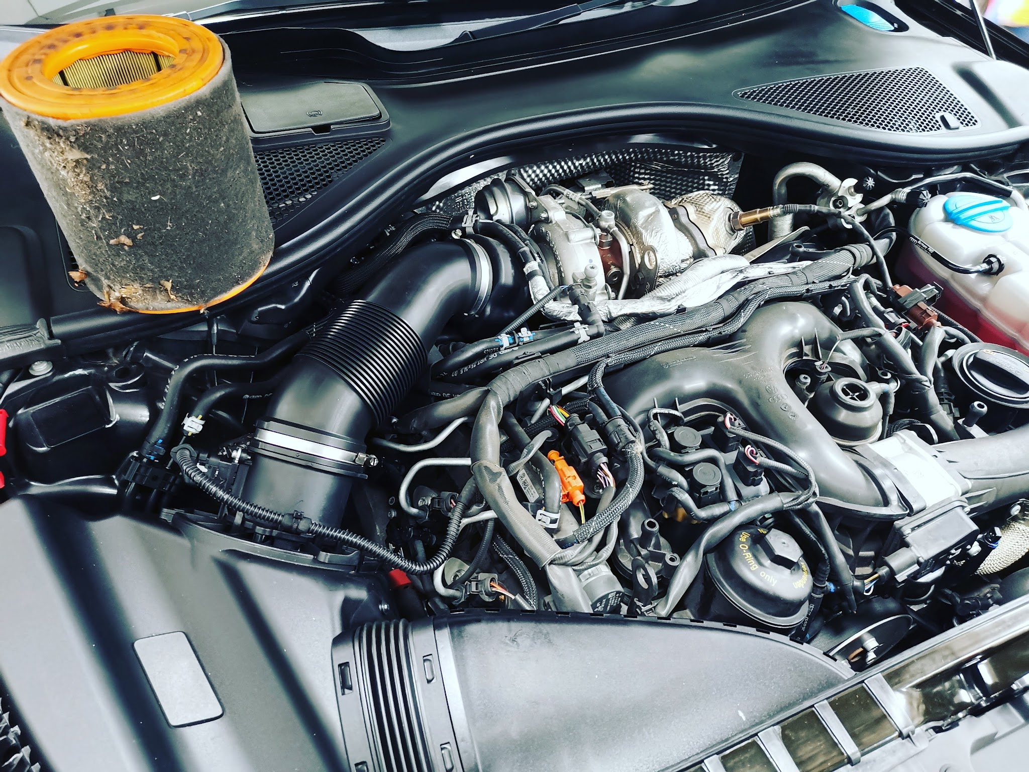 Engine bay of an Audi with a V6 TDI engine, the air filter housing removed